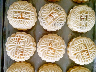 12、广式月饼,蛋黄莲蓉的包法需要注意的是,先把莲蓉搓圆,在上面戳一个小洞,直接把蛋黄往洞里塞,两个手配合着一个手把蛋黄往下按,另一个手把莲蓉慢慢往上推,直到把蛋黄全部包住,再用饼皮把它包起来,再用模具把它压膜好,压模手法和五仁馅料的一样,在这里我就不多说了。