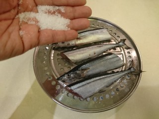 4、鹽巴燒烤秋刀魚,找個不會積水的容器，比如蒸網，魚放蒸網上頭，由高處撒海鹽，正反面都要。