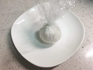 4、火腿芝士雪娃娃饭团#诞愿有你#,把保鲜膜收紧，米饭把火腿和芝士包住，团成圆饭团。