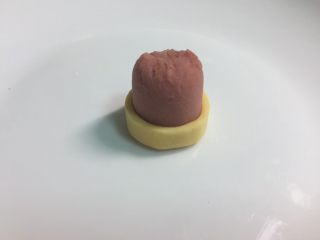 8、火腿芝士雪娃娃饭团#诞愿有你#,把芝士围在圆火腿段的边缘，做成帽子。