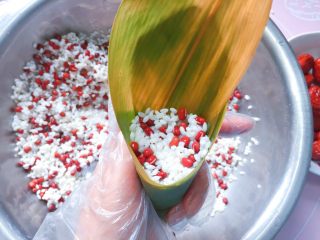 11、红豆红枣牛角粽,再加入2/3的红豆、糯米，压实（九分满即可）。