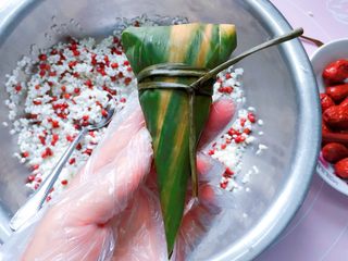 13、红豆红枣牛角粽,最后用粽绳扎紧打结，一个酷似牛角的粽子就完成啦。