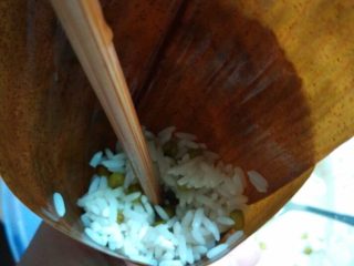 6、碱水粽,如图将竹叶卷好放入拌好的糯米用筷子撮紧包好