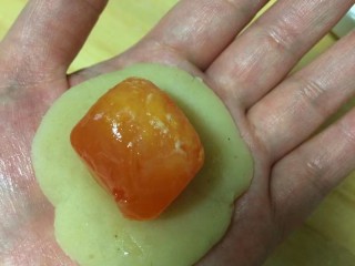 9、#甜味#莲蓉蛋黄月饼,先把莲蓉馅按扁包入蛋黄
