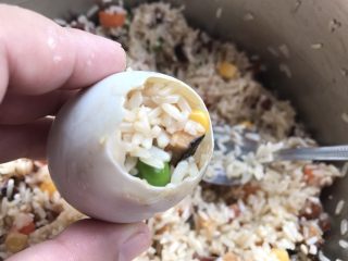 14、不会包粽子就做快手的糯米蛋吧,取小勺把糯米材料加到咸蛋中，大概八九分满。