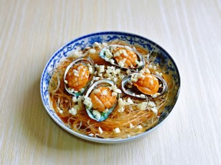 12、蒜蓉粉丝蒸鲍鱼,把腌制好的鲍鱼放在上面,撒上切好的蒜末。