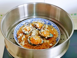 13、蒜蓉粉丝蒸鲍鱼,上蒸锅蒸6分钟即可关火。