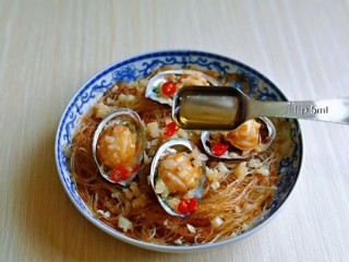 14、蒜蓉粉丝蒸鲍鱼,取出蒸好的粉丝蒸鲍鱼盘,淋上一勺热油。(一定要把油烧热再拎上去哈)