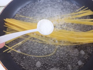 2、香菇意面,先放一勺盐。