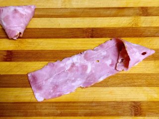 3、培根包饭—小小炒饭的另一种高大上吃法,取一片培根放在案板上，一端卷出三角形状。类似包粽子的样子。