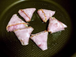 9、培根包饭—小小炒饭的另一种高大上吃法,平底不粘锅倒入适量植物油，放入培根包饭，盖上锅盖小火煎。