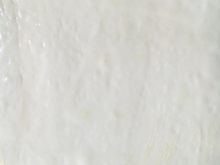 6、日式香浓练乳面包,从底部捞出，排气擀平，涂上练乳。切成4等份