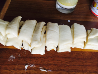 8、日式香浓练乳面包,从底部捞出，排气擀平，涂上练乳。切成4等份