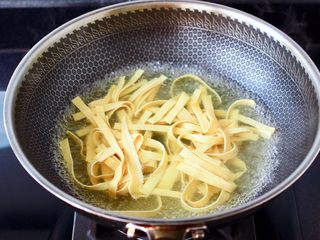 6、酸汤花甲粉,再把豆腐皮放入锅中进行焯水，变软即可捞出沥干水分。