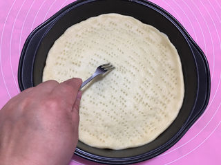 14、美味的牛排披萨,用叉子将披萨皮扎满小孔，避免烘烤时饼皮受热鼓起。