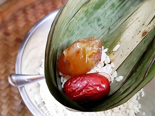 5、古法特制、天然植物碱水粽,用事先处理好的粽叶开始裹粽。