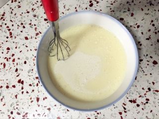 7、奶黄冰皮月饼,搅拌均匀，用手动打蛋器在上层来回划圈，让油与牛奶糊充分融合。