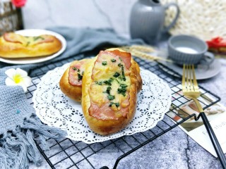 20、香葱培根芝士面包,戴上隔热手套将烤盘取出，立即刷上一层玉米油，这样会更好的锁住面包的水份。