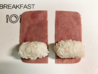 4、小萌猪火腿饭团,米饭团成和火腿片等宽的饭团，放在火腿片的一端。
