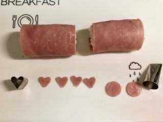 6、小萌猪火腿饭团,在另一片火腿片上，用心形模具切下4个爱心形做小猪的耳朵。用裱花嘴圆形的一端切下两个圆形做小猪的鼻子。