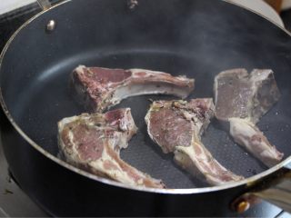 10、香煎小羊排配百里香烤南瓜,继续将锅烧热到冒烟的程度,放入羊排煎,煎一分钟再翻面(不要频繁翻面,以免内部肉汁流失)我这个每面煎两分钟不到些。可撒上些许黑胡椒碎。别太多,也别太早撒,以免黑胡椒煎糊出苦味。羊排熟度判断见小贴士。