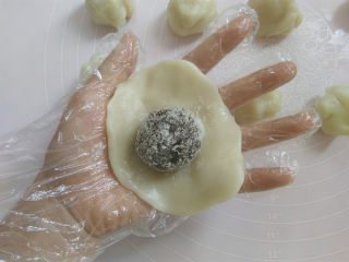 9、白玉饼皮月饼, 取一个面团压扁，包上豆沙馅，像包包子那样包起来，捏一下收口