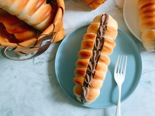 19、巧克力卡士达面包,卡士达酱装裱花袋，面包凉透后用刀把中间切开，不要切断，中间挤入巧克力卡士达酱就可以了。