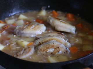 9、咖喱鸡翅,放入鸡翅，加盖转中小火炖煮十分钟。