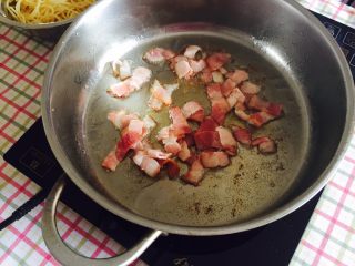 7、“黑胡椒培根牛肉粒意面”,锅里留底油，加入培根片，小火煸炒，炒至培根变色，之后加入牛肉粒翻炒几下。
