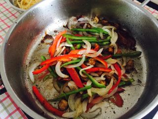 9、“黑胡椒培根牛肉粒意面”,然后加入洋葱丝和彩椒丝一起翻炒几下。