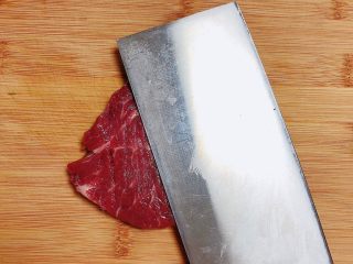 7、迷迭香黑胡椒牛排,将牛排片放在菜板上，用刀面做轻轻拍打（卖牛排鲜肉的欧巴给的建议），这样会更好吃。