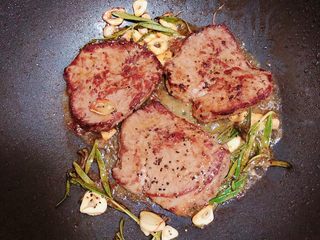 15、迷迭香黑胡椒牛排,黄油融化后，再撒上一些黑胡椒碎。让牛排上充分侵在黄油里，翻一面让牛排继续侵泡在黄油中。