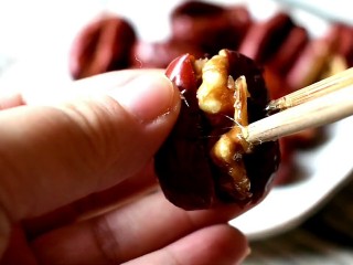 13、枣夹核桃,将包裹上糖浆的核桃仁塞入红枣里