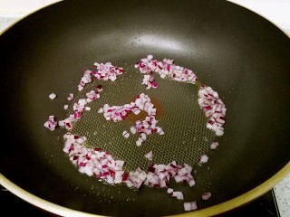 8、奶油蘑菇培根意粉,倒入洋葱粒,小火翻炒至闻到香气。