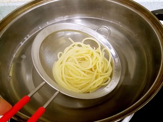 17、奶油蘑菇培根意粉,酱汁做好,意粉也熟了。用漏勺捞起意粉。