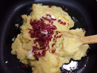 7、Diy手工蔓越莓绿豆糕,平底锅烧热，放入核桃油，绿豆沙，蔓越莓果干，白砂糖和炼乳，小火慢炒，直至绿豆沙变干，可以捏成团。