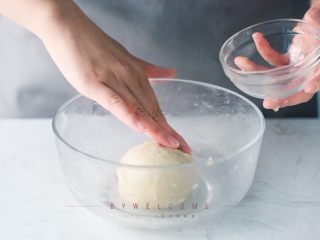 4、麻辣小龙虾披萨,揉好的面团放入碗中，在面团表面抹点水，封上保鲜膜，放在室温下发至两倍大（冬天气温低可以使用烤箱自带的发酵功能）；