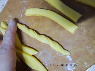 10、橙香无油无糖磨牙棒,	将面条扭一扭，头尾用手将面团整圆润一点，这样烤好以后不容易弄伤孩子的嘴巴