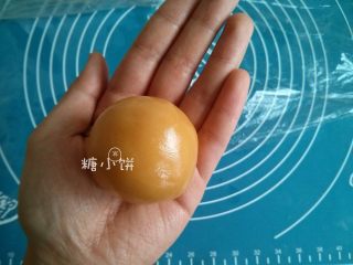 4、【椰蓉广式月饼】 ,推饼皮直到包裹住整个馅料，用手搓一搓让饼皮分布均匀