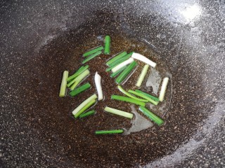 7、木耳炒肉丝,锅里继续倒油烧热，下入小葱炒香。