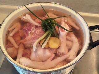 2、金手指爱上银肘子, 冷水没过鸡爪子。加入。葱姜两勺料酒，烧开。洗净。