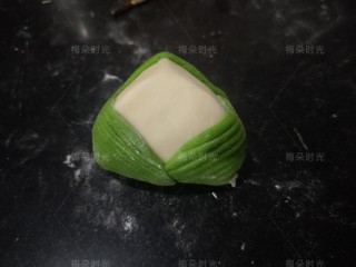 11、花样馒头——粽子馒头,然后用小刷子在粽叶的背面刷点水。粘在白色面团上。左边一片，右边一片。后面一片。如图，露出白色面团三角区域。