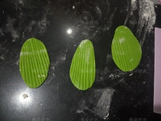 10、花样馒头——粽子馒头,然后做三片粽叶。每片6克，先搓成圆球，再擀开，再用刮板纵向压上纹路。三片形状不是一模一样也没关系。