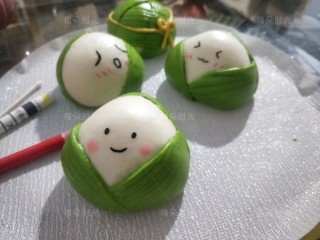 19、花样馒头——粽子馒头,蒸熟后，用黑色烘培笔（就是可食用色素笔）在空白处给粽子画上各种表情。用红色笔画出腮红。
