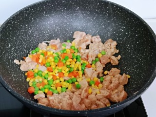 12、披萨新吃法～奥尔良鸡丁披萨,待鸡肉炒至变色后，加入玉米粒，豌豆，胡萝卜丁，小火翻炒，加入一小勺纯净水，中小火煮3-5分钟，将食材煮熟即可。