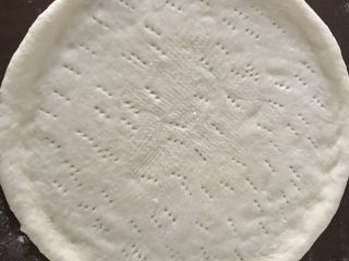 7、超级好吃的榴莲披萨,将面团擀开整形成中间薄，四周略厚的圆形。中间用叉子叉洞，以免烘烤时鼓起。