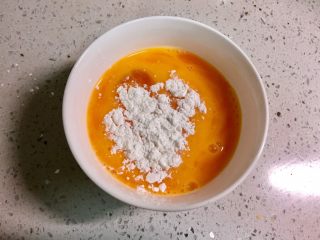 4、黄金黑米卷,加入一勺淀粉，拌匀，淀粉能让鸡蛋不容易煎散，口感更嫩。