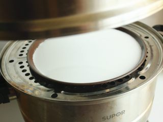 7、凉皮,蒸锅加水烧开后，放入披萨盘子，盖盖子大火蒸2分钟。