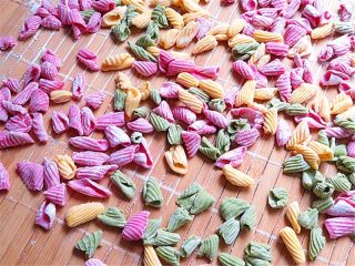 8、彩色贝壳意面,将其他颜色面片也推成这样，如果一次做的很多，可以将多余的放在阴凉的地方风干，风干后的面可装起来放冰箱冷冻层储存