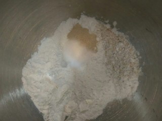 3、全麦核桃包～软欧包,面包粉，全麦粉、砂糖、酵母放入搅拌桶，慢速搅拌均匀。